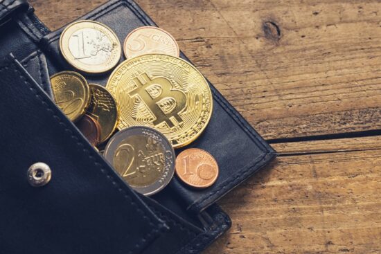 A bitcoin resting in a wallet placed on a wooden table, symbolizing digital currency and financial investment.