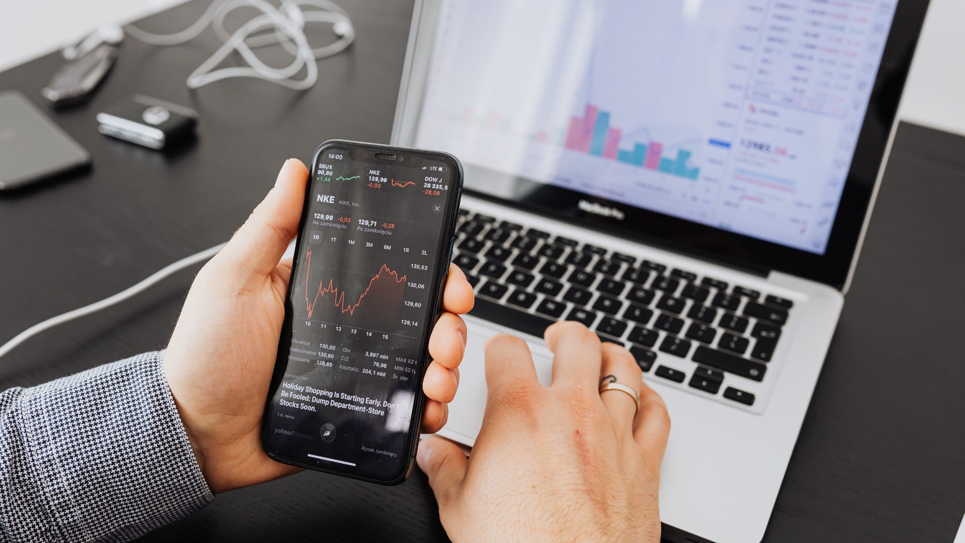 A man intently examines stock market data on his smartphone, showcasing modern investment practices