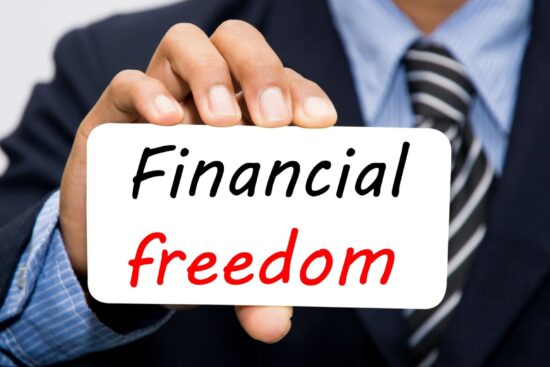 Financial Freedom' card held in hand.