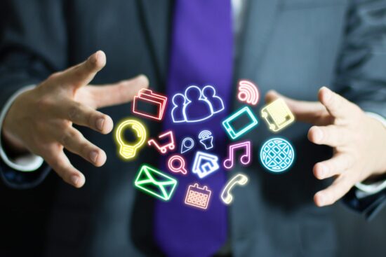 Businessman displaying vibrant icons with his hands, symbolizing innovation and digital communication in a professional setting.