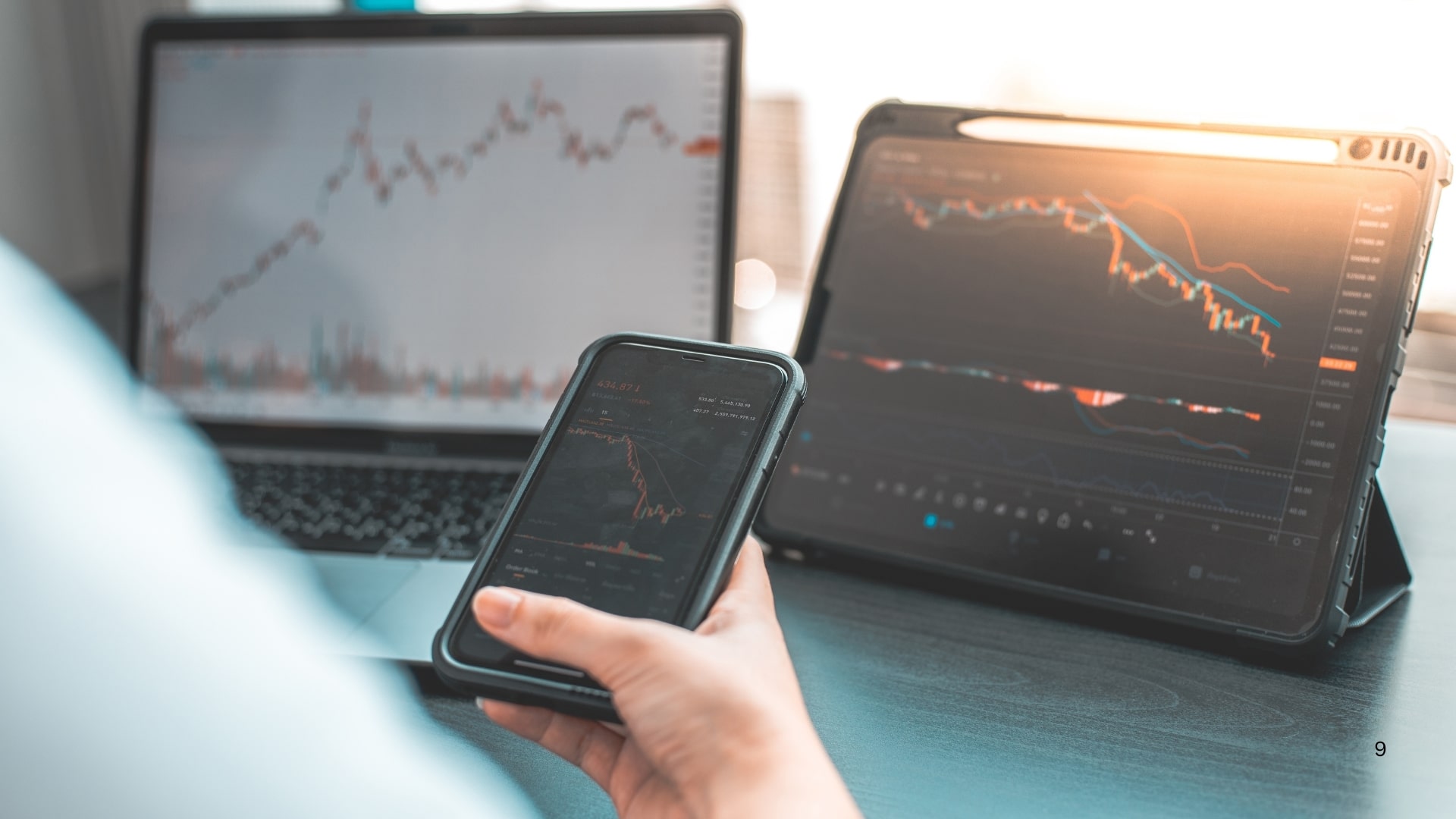 A laptop and smartphone displaying stock market trading charts and data, illustrating modern investment practices.