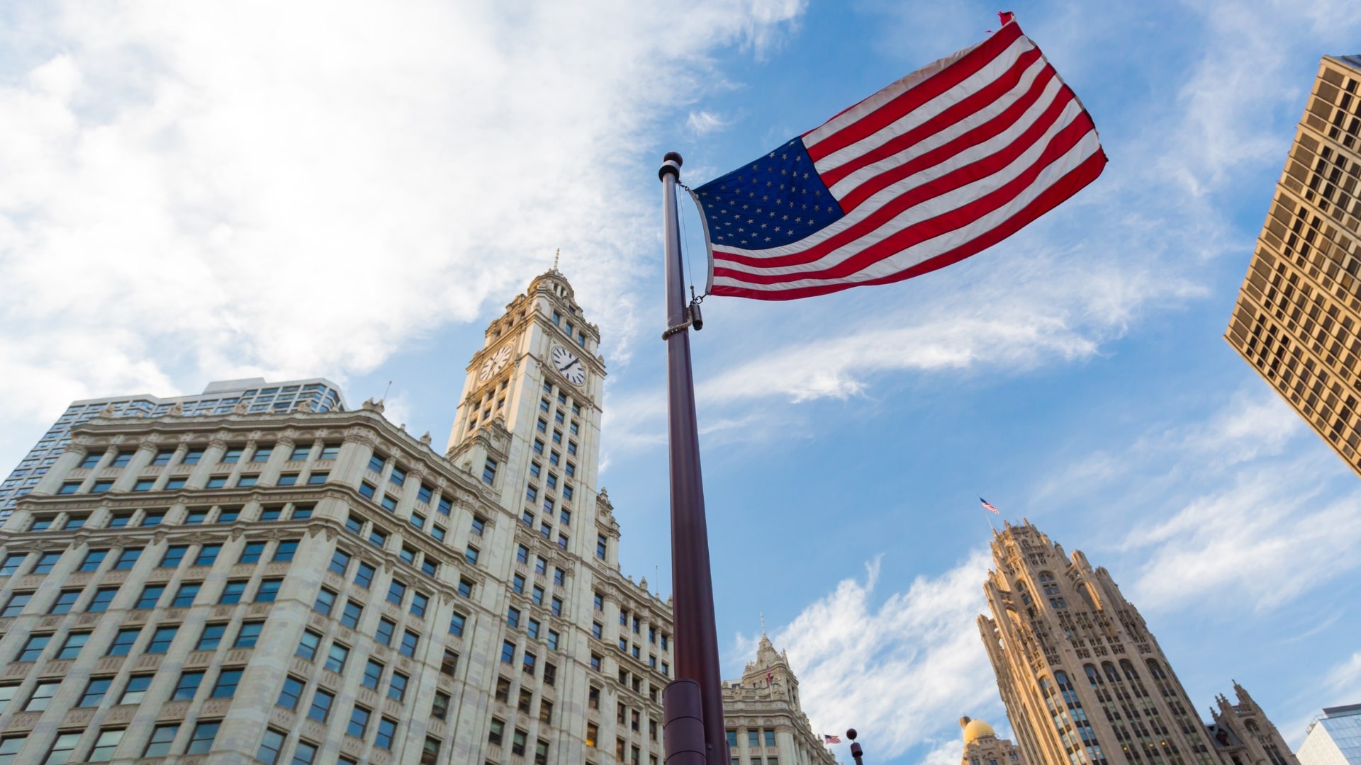 An American flag waves proudly in front of towering skyscrapers, symbolizing patriotism Trump's amidst urban architecture.